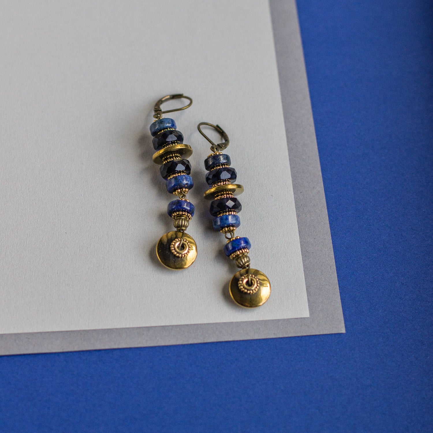 Find the perfect gift with these one-of-a-kind, handmade long-hanging earrings featuring beautiful blue, black, and gold rondelles.