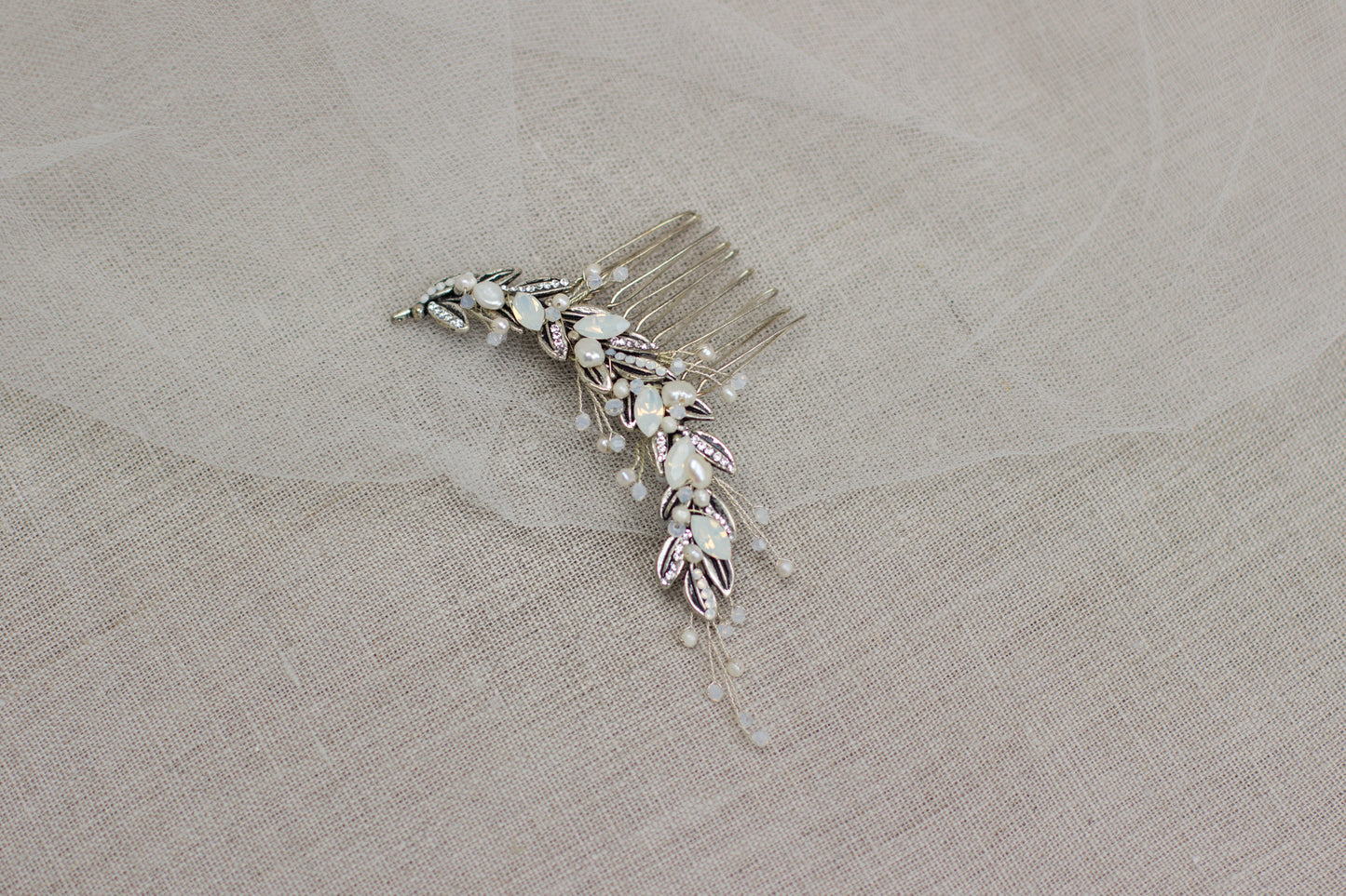 Shop for unique handmade bridal hair accessories in Europe's online wedding boutique. This one-of-a-kind crystal and leaf wedding headpiece, bridal hair comb will make a perfect addition to your wedding day look. White opal hair adornment.