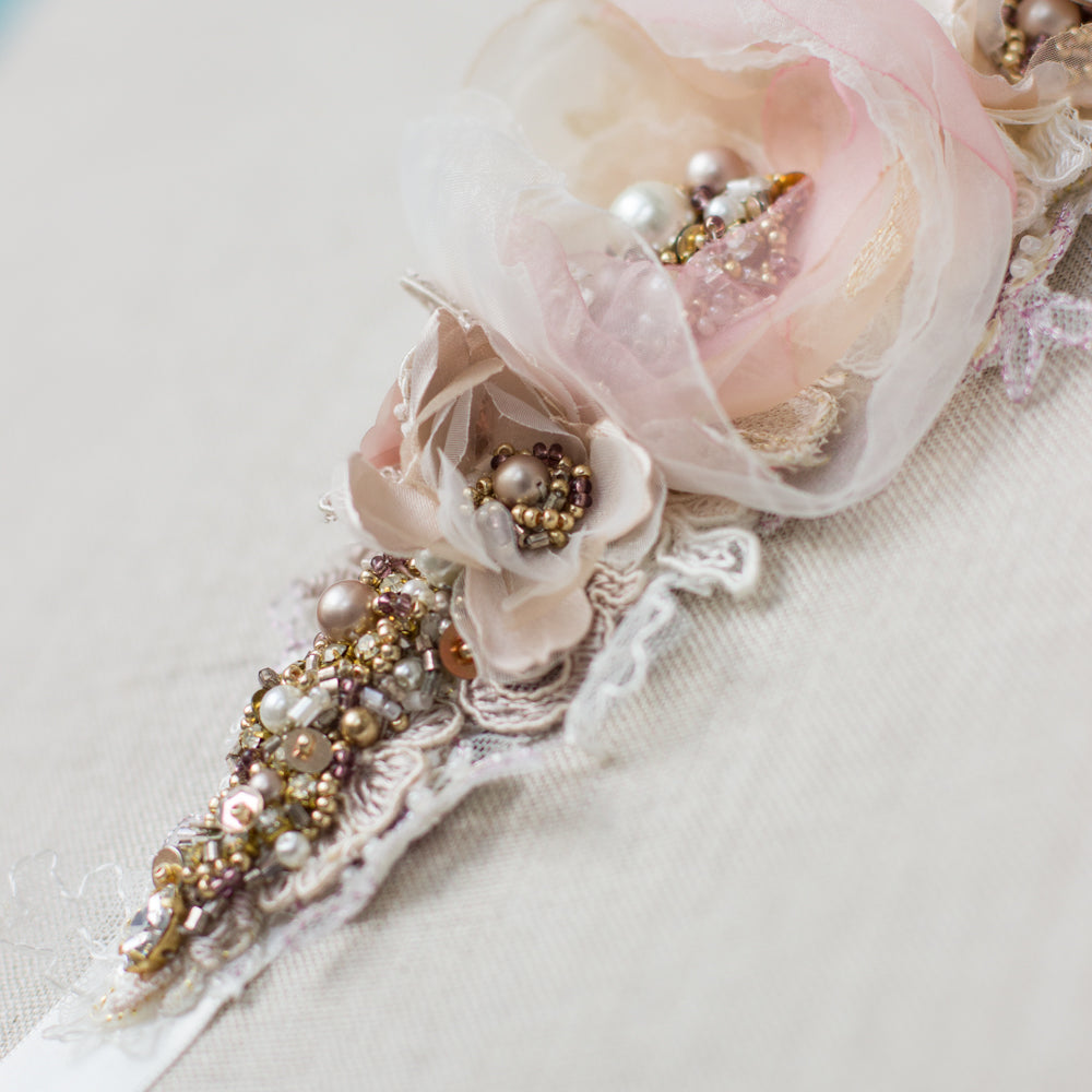 A beautiful handmade wedding dress belt sash that features ivory, blush pink, rose, and mauve hues. Floral design bridal belt sash is perfect for rustic, spring, or summer weddings. Online bridal boutique. One-of-a-kind wedding accessories.