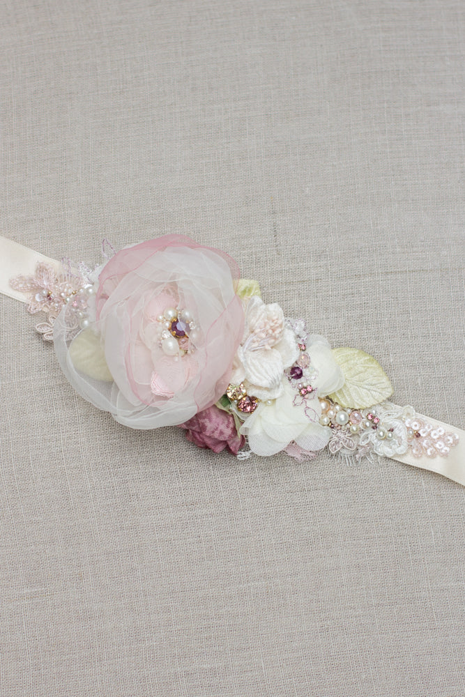 Romantic handmade wedding dress belt sash features ivory, blush pink, dusty rose, and green accents. Floral design bridal sash belt is perfect for rustic, spring, or summer weddings. An online boutique with one-of-a-kind wedding accessories.