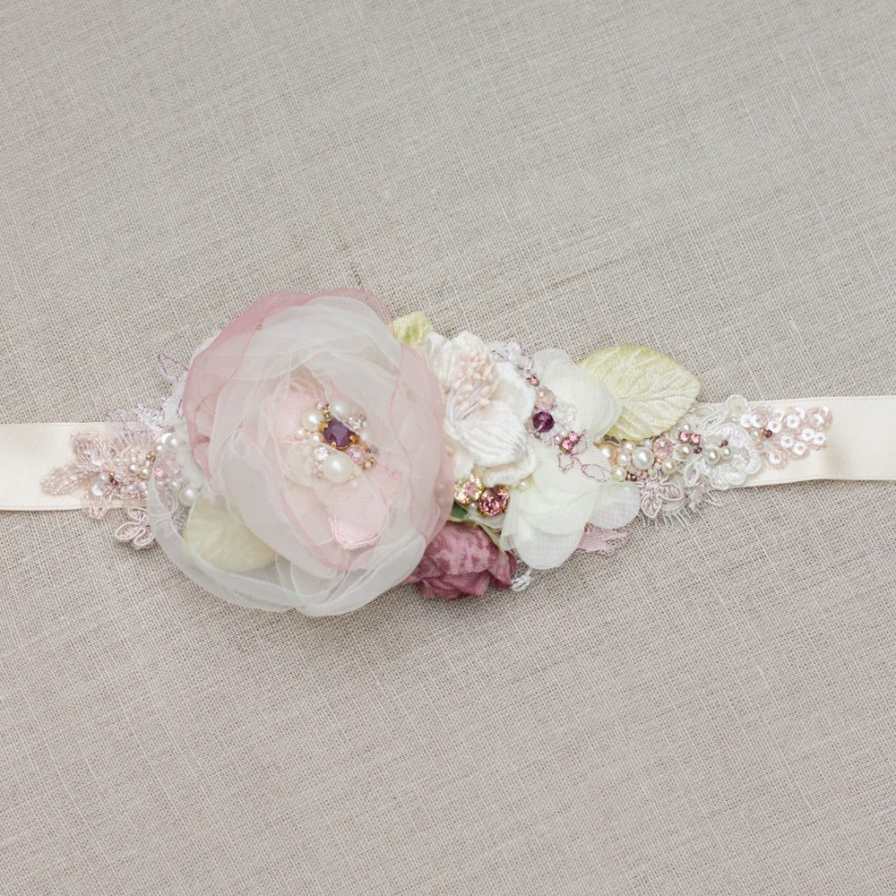 Romantic handmade wedding dress belt sash features ivory, blush pink, dusty rose, and green accents. Floral design bridal sash belt is perfect for rustic, spring, or summer weddings. An online boutique with one-of-a-kind wedding accessories.