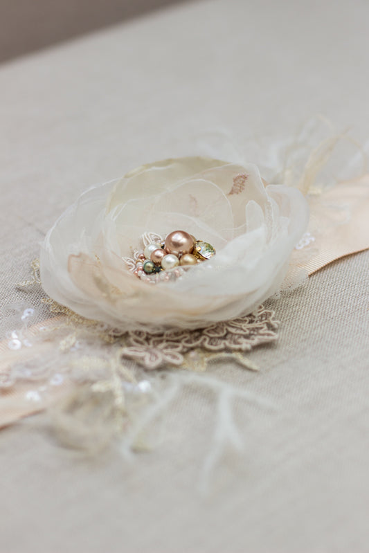  A handmade wedding dress bridal sash belt with a champagne flower, feathers, sage green, and rose gold accents, perfect for rustic, spring, or summer weddings. Find unique wedding accessories at this online boutique. 