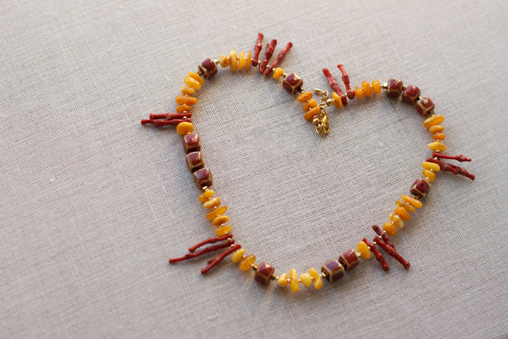  A bright & unique fashion accessory. Amber necklace. Coral necklace. Geometric shape jewelry. Gold, yellow, and red necklace. Fashionable look for summer.