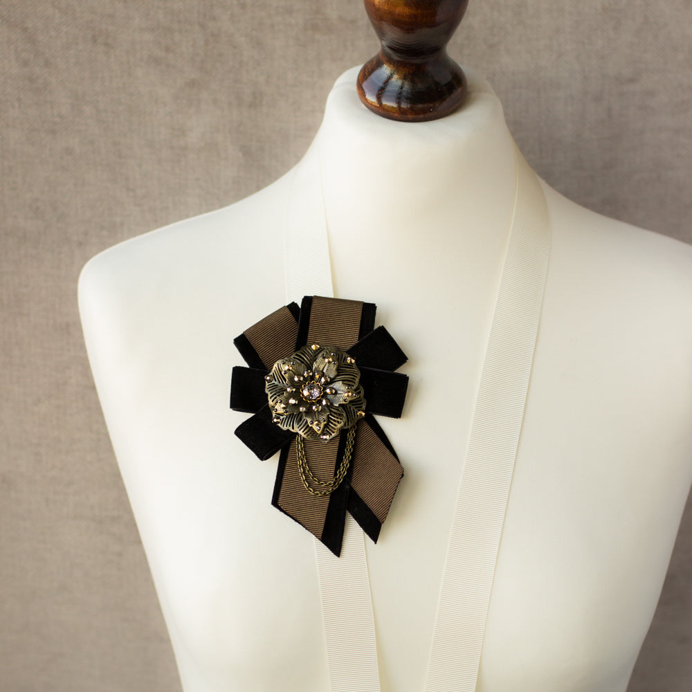 An unique handmade brown and black ribbon brooch, featuring a large metal flower design. It's a one-of-a-kind accessory that makes for a great gift idea.