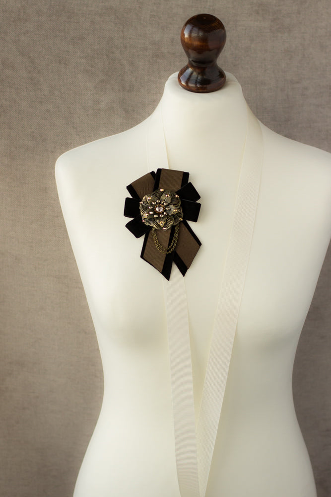An unique handmade brown and black ribbon brooch, featuring a large metal flower design. It's a one-of-a-kind accessory that makes for a great gift idea.