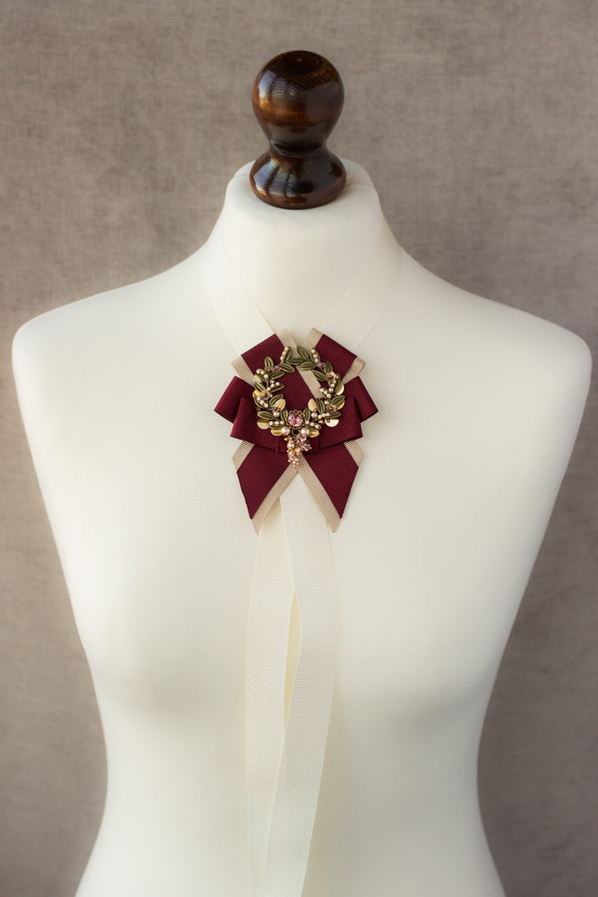 Shop this unique handmade leaf wreath brooch featuring burgundy, blush, and beige ribbons. Perfect for any evening occasion, it adds an elegant touch to any outfit and makes for a great gift idea.