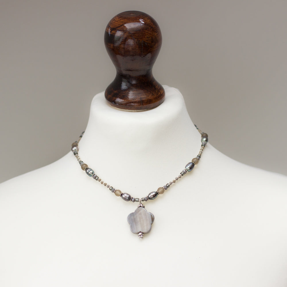 Shop a handmade gray necklace featuring freshwater pearls, glass, and a mother-of-pearl pendant. This beautiful natural stone necklace is perfect as a gift.