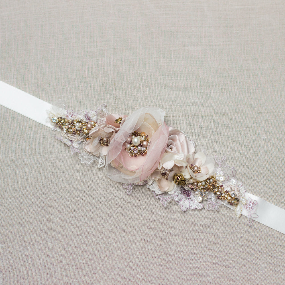 A beautiful handmade wedding dress belt sash that features ivory, blush pink, rose, and mauve hues. Floral design bridal belt sash is perfect for rustic, spring, or summer weddings. Online bridal boutique. One-of-a-kind wedding accessories.