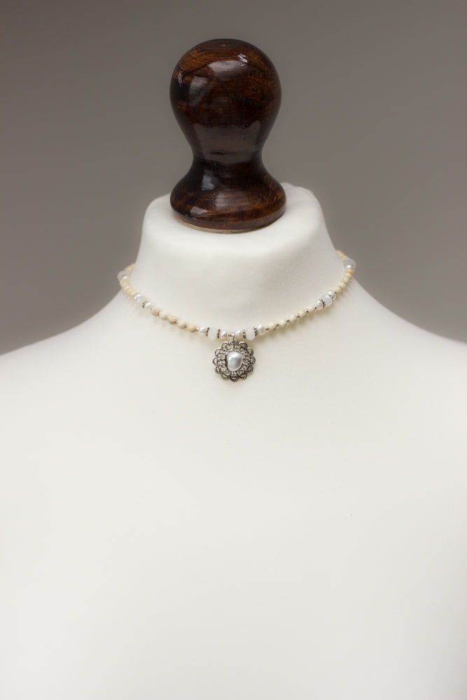 Shop a beautiful handmade pearl and crystal pendant necklace featuring natural stones in ivory, white, and silver - the perfect gift idea!
