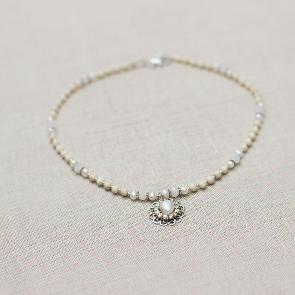 Shop a beautiful handmade pearl and crystal pendant necklace featuring natural stones in ivory, white, and silver - the perfect gift idea!