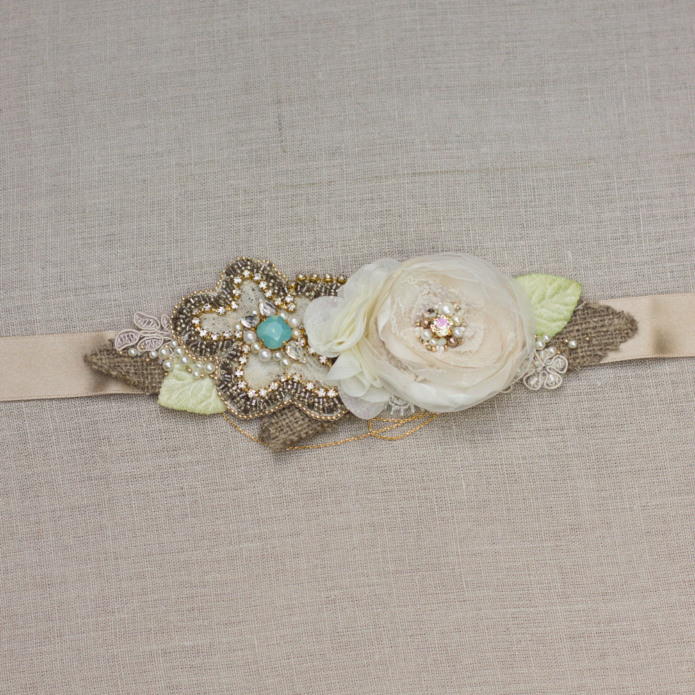 A unique handmade wedding dress belt sash. Floral design bridal belt sash features champagne, gold, greenish and burlap perfect for rustic, spring, or summer weddings. Online bridal boutique, which offers one-of-a-kind wedding accessories.